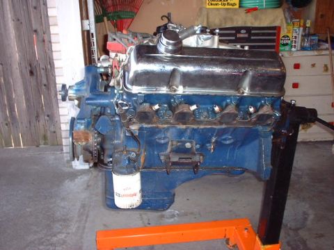 1967 Ford Mustang - A blue engine, likely from a classic car, is mounted on an orange engine stand. A white oil filter is visible on the side.