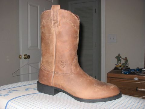 1988 Ford Bronco - A single brown cowboy boot is shown in a close-up view, resting on a patterned surface.