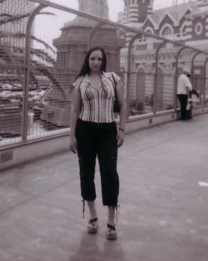 Woman standing on a pedestrian bridge in a sepia photo