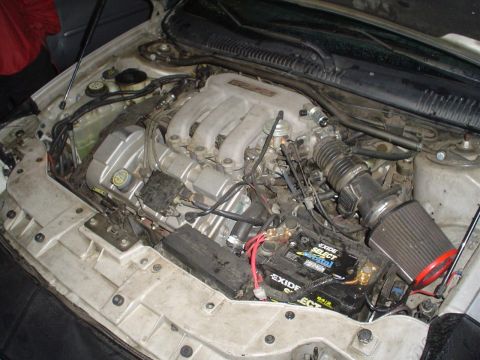 1993 Ford Taurus - Ford Taurus engine bay shows the V6 engine, battery, and intake system.