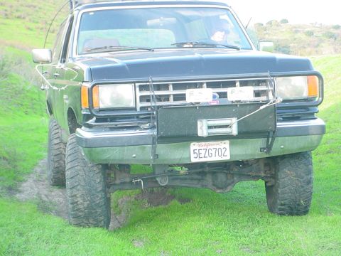 1988 Ford Bronco - Front view of a lifted 1987 Ford Bronco with off-road tires and a winch mounted on the bumper.