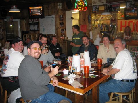 2002 Ford Taurus - Friends enjoy drinks and conversation at a table in a rustic bar setting.