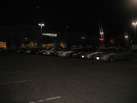 2002 Ford Taurus - Several cars are parked in a lot at night, with a Cambridge store in the background.