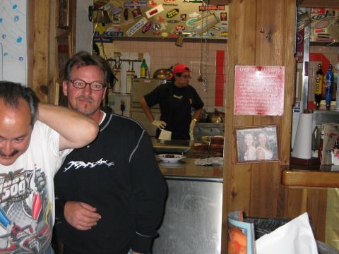 2002 Ford Taurus - A group of people are gathered inside a restaurant, with a sign for 'Oyster Lovers' visible on the wall.