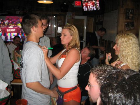 2002 Ford Taurus - A woman in a Hooters uniform signs a man's t-shirt while people gather around in a bar.