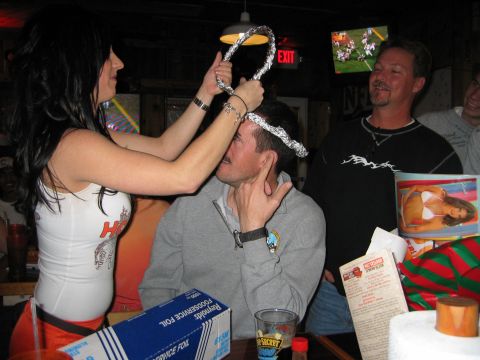 2002 Ford Taurus - A woman places a foil crown on a man's head while another man watches.