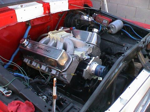 1979 Ford Bronco - Close-up of a Ford Racing engine, likely undergoing a build or modification, with chrome valve covers and custom intake manifold.