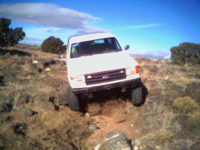 White 1987 Ford Bronco climbing rocky terrain