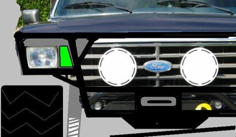 1985 Ford Bronco - The front grille of a dark blue Ford Bronco shows a Ford emblem and auxiliary lights.