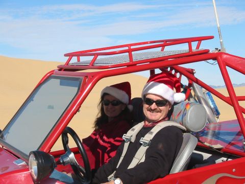 1993 Ford Taurus - Two people in a red off-road buggy enjoy a sunny day, both wearing festive Santa hats.