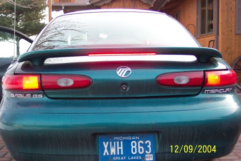 1996 Mercury Sable - The rear of a green Mercury Sable GS sedan is shown with its brake lights illuminated.