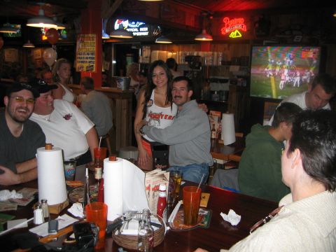 2002 Ford Taurus - A group of friends enjoy a meal and drinks at a Hooters restaurant while watching a football game.