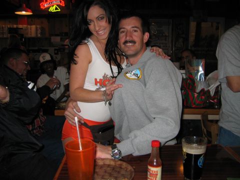 2002 Ford Taurus - A couple poses for a photo at a bar, with the woman wearing a Hooters uniform and the man in a gray sweatshirt.