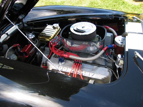 2002 Ford Taurus - The engine bay features a V8 engine with prominent red spark plug wires and a chrome air filter housing.