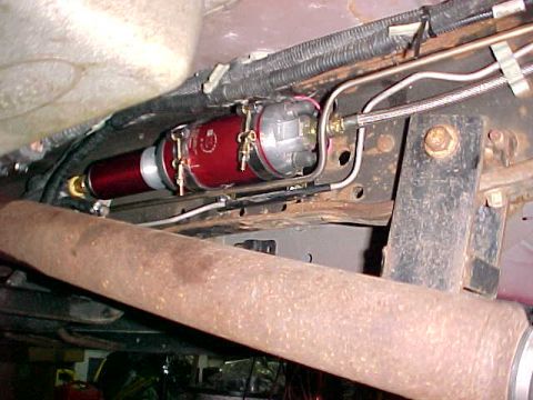 2000 Ford F-250 - Underside view of a vehicle's fuel system components, including a red fuel filter and associated lines.