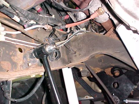 2000 Ford F-250 - Close-up view of the vehicle's undercarriage, showing mechanical components and wiring harnesses.