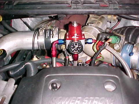 2000 Ford F-250 - Engine bay detail showing a fuel pressure regulator and gauge. Text 'SUPERMOTORS' is visible.