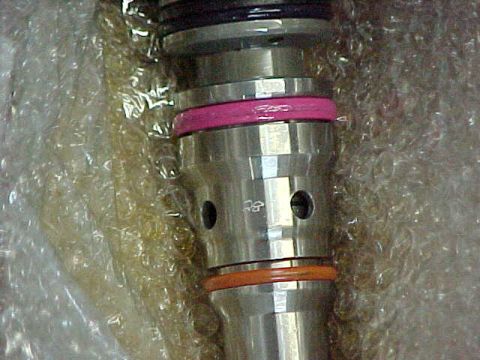 2000 Ford F-250 - A close-up view of a metal automotive part, possibly a fuel injector, with colored O-rings and bubble wrap packaging.
