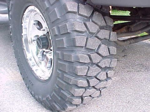 2000 Ford F-250 - A detailed view of a truck's wheel and tire, highlighting its tread and polished rim.