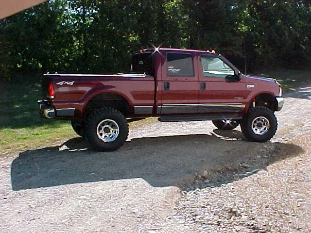 Red 2000 Ford F-250 pickup truck parked on a gravel road