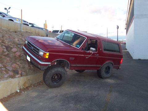 1991 Ford Bronco - This Ford Bronco is positioned on a curb with its front wheels elevated.