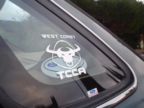 1993 Ford Taurus - A car's rear window displays various stickers, including 'WEST COAST TCCA' and a Ford Racing decal.