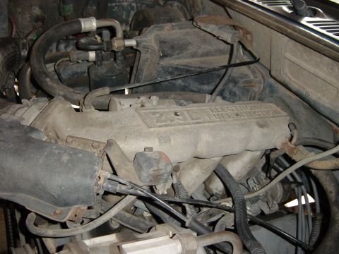 1993 Ford Bronco - Close-up of an engine bay, showing the "2.9L ELECTRONIC FUEL INJECTION" label on the intake manifold.