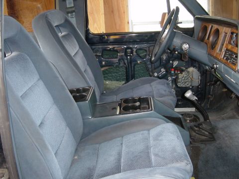 1993 Ford Bronco - Interior of a 1993 Ford Bronco, bucket seats and a center console with cup holders.