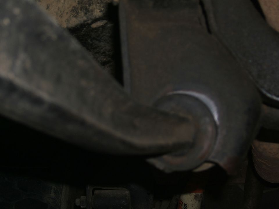 Close-up of a metal suspension part with a rubber bushing