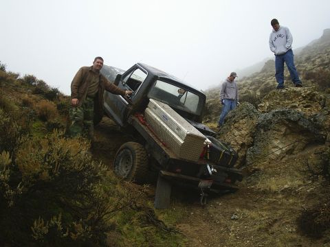 1978 Ford Bronco - Three men observe a truck that appears to be stuck on a difficult, off-road terrain.