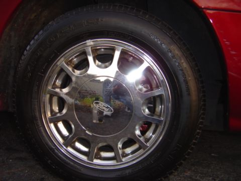 1998 Ford Taurus - Close-up of a chrome wheel the Ford logo, consistent with a 1998 Taurus.