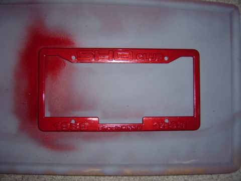 1998 Ford Taurus - A red license plate frame with embossed text is shown against a neutral background.