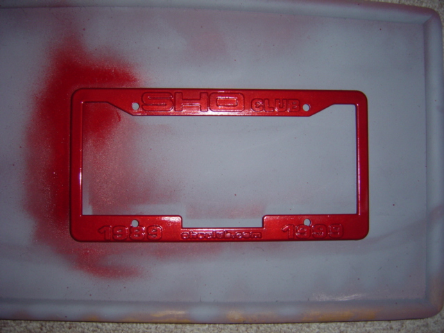 Red license plate frame with embossed "SHO CLUB" and "1998 SHOclub.com 1998" text