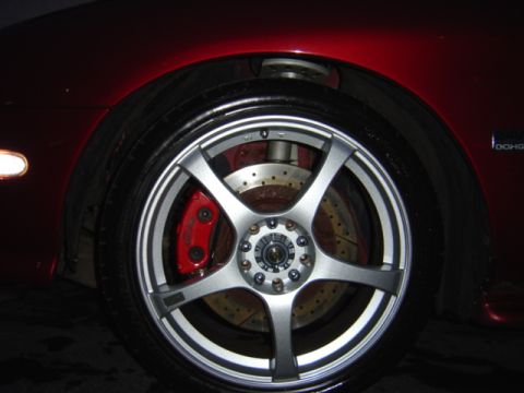 1998 Ford Taurus - Close-up of a red car's wheel custom silver rims and bright red brake calipers.