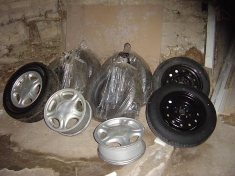 1998 Ford Taurus - Various wheels and tires are stored in a basement setting.