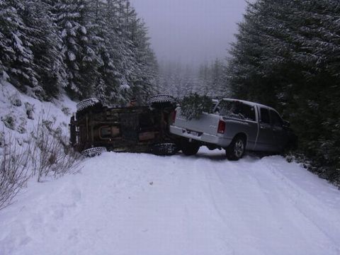 1995 Ford Bronco - Two trucks involved in an incident on a snowy, wooded road.