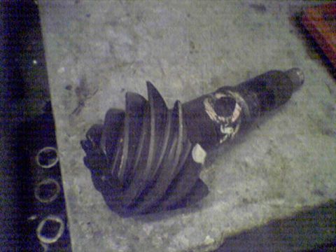 1994 Ford Bronco - A differential gear is shown with spiral teeth and markings on its shaft.