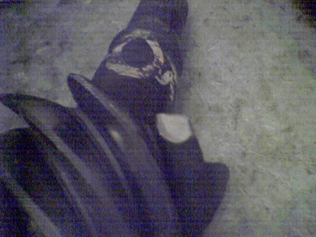 Dark gear with a circular cutout and a chipped edge, on a textured surface