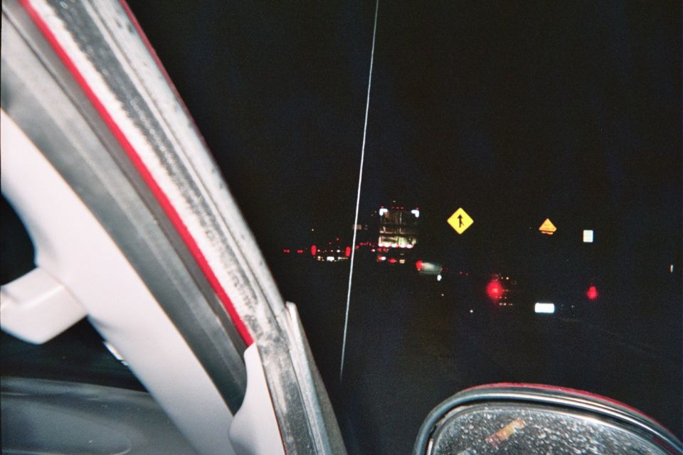 Night driving view of road lights and yellow warning signs