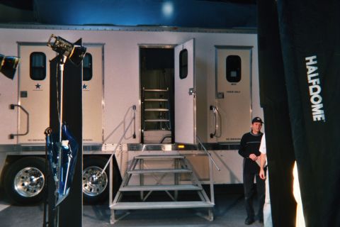 1990 Ford Bronco - White production trailers marked with stars and crew-only doors, with metal fold-out steps and a man standing beside a Halfdome banner.