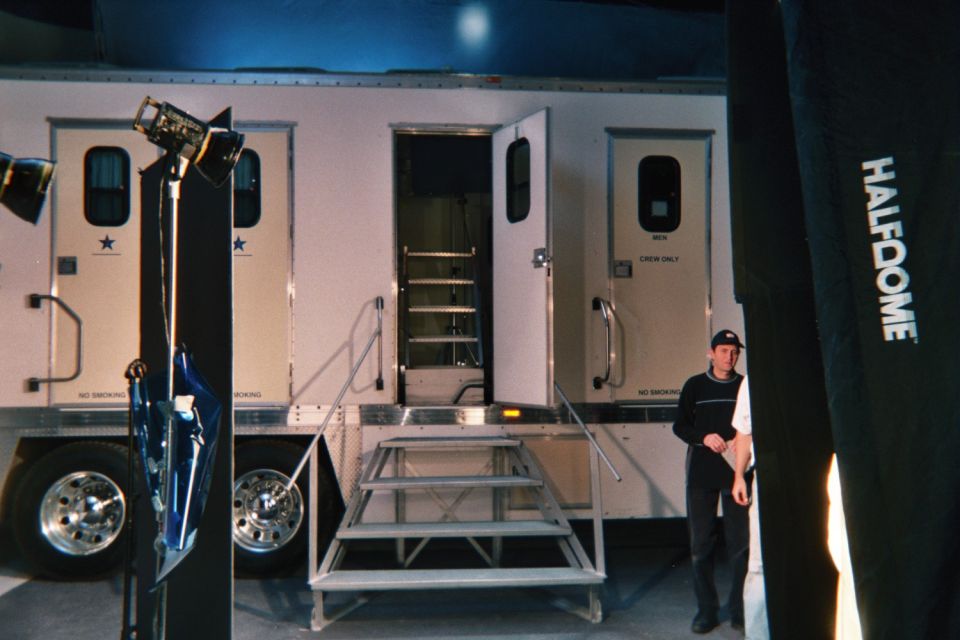 White production trailers with star logos and fold-out steps, a man standing beside a Halfdome banner