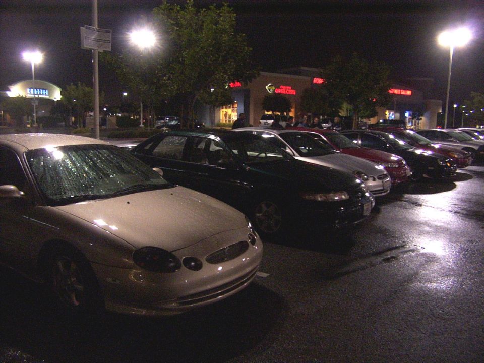 Front view of a beige 1996 Ford Taurus with rain on the windshield
