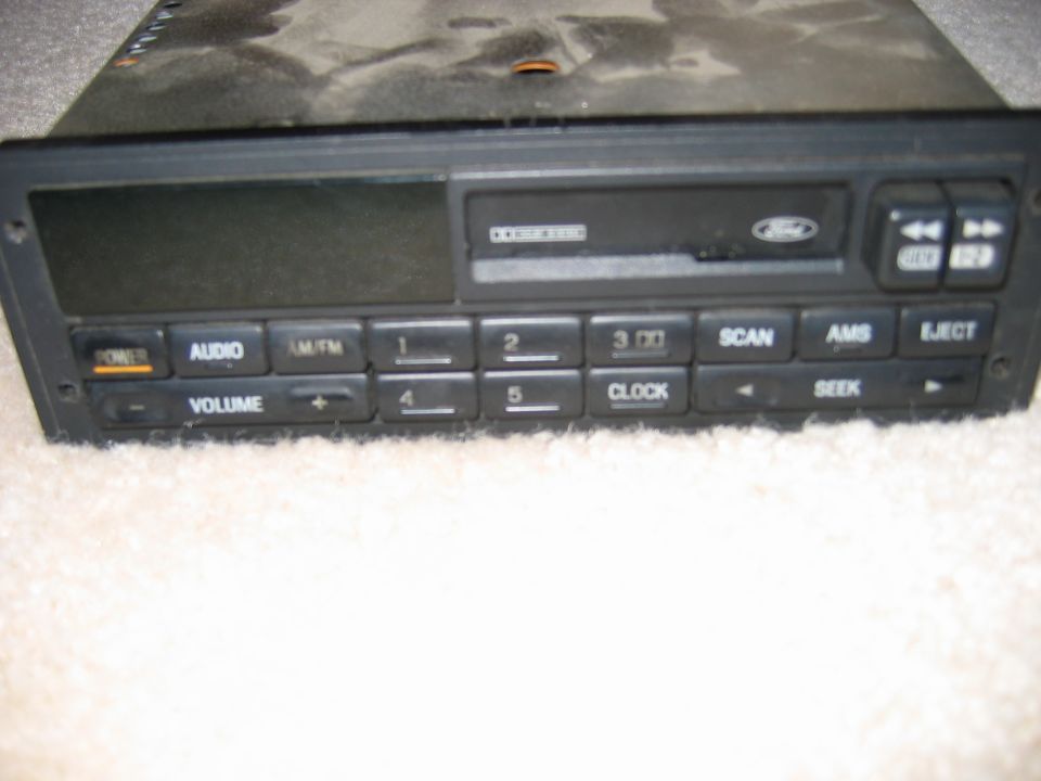 Ford OEM AM/FM cassette stereo head unit sitting on beige carpet