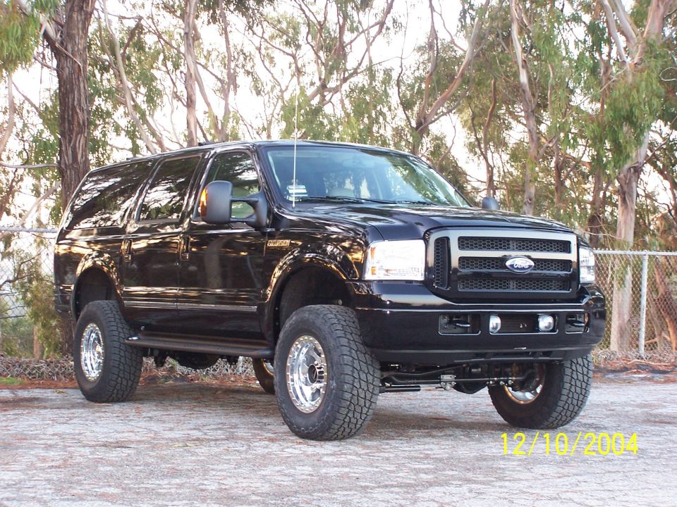 Black Ford Excursion SUV lifted on chrome wheels, parked outdoors, dated 12/10/2004