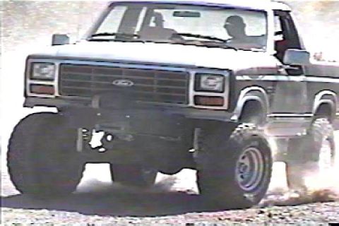 1984 Ford Bronco - Ford Bronco with large tires driving off-road.