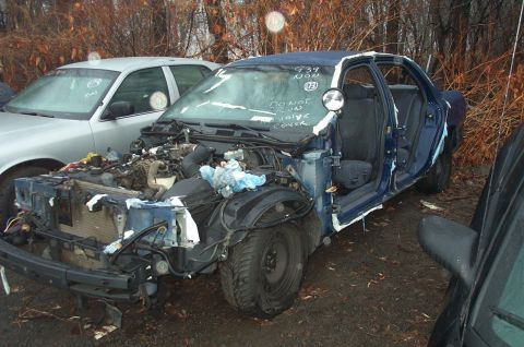 1991 Ford LTD Crown Victoria - This damaged police car has writing on the windshield that says 'DO NOT RUN VALVE COVER'.
