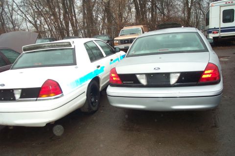1991 Ford LTD Crown Victoria - Two Ford Crown Victorias are seen from the rear in an outdoor lot, one with blue markings.