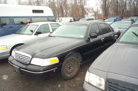 1991 Ford LTD Crown Victoria - A black Ford Crown Victoria is parked in a lot with other cars and a van.