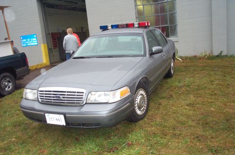 1991 Ford LTD Crown Victoria - This 1991 Ford Crown Victoria LTD police car is seen from a 3q-front angle, a light bar on its roof and a license plate reading 257 NHP.
