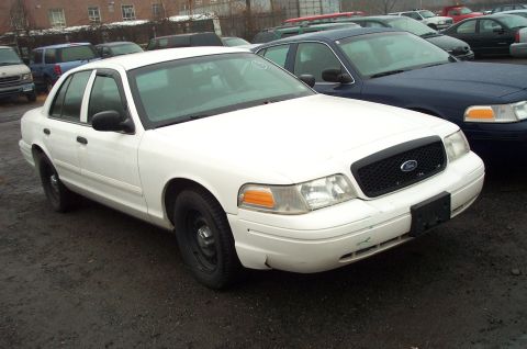 1991 Ford LTD Crown Victoria - A white Ford Crown Victoria is parked in a lot with other vehicles. The front of the car is visible.